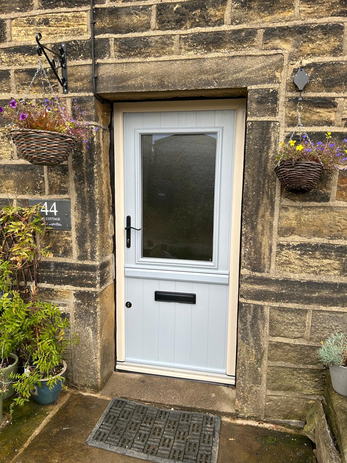 Duck Egg blue Beeston Flint composite stable door in cream frame with Stippolyte glass and antique black swept handle and letterbox