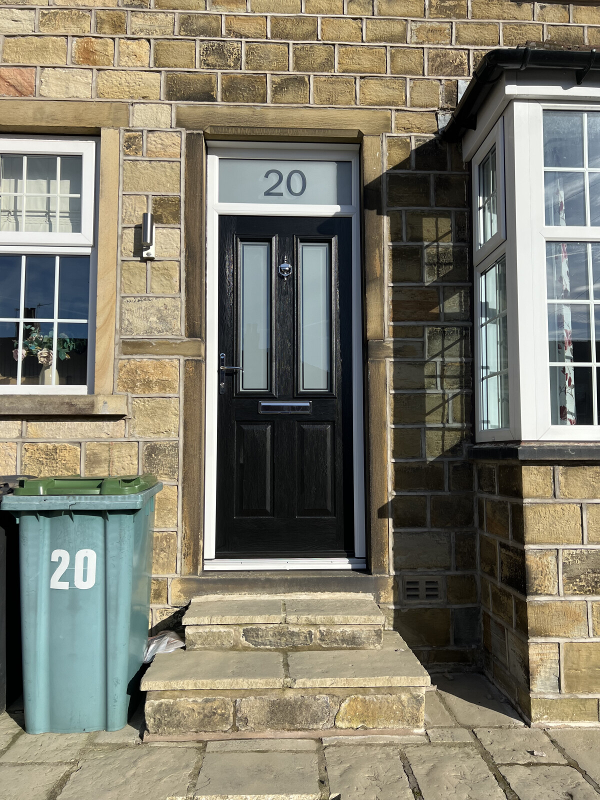 Black on white Ludlow composite door with Victorian glass and number.