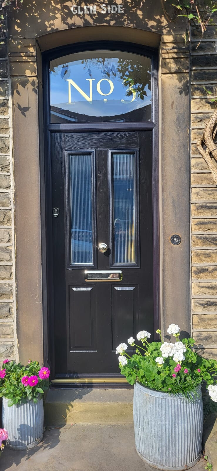 Black Ludlow composite door with gold heritage letterbox and door knob. Gold number in top light applied by customer.