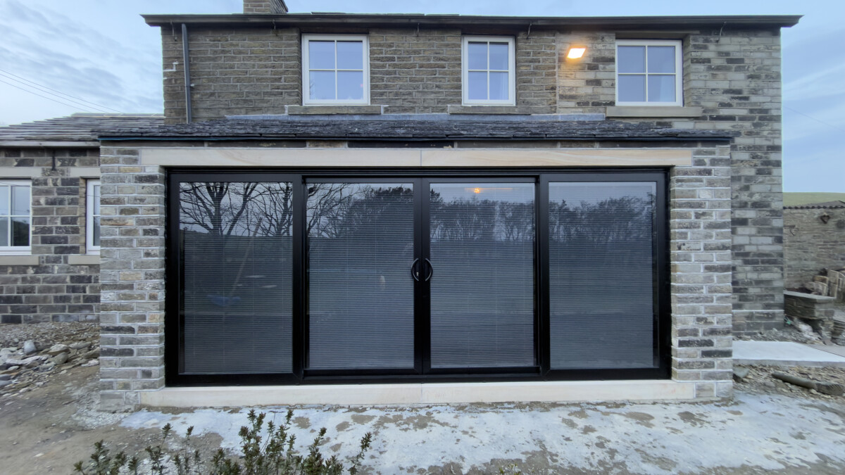 Black aluminium sliding doors with black integrated blinds