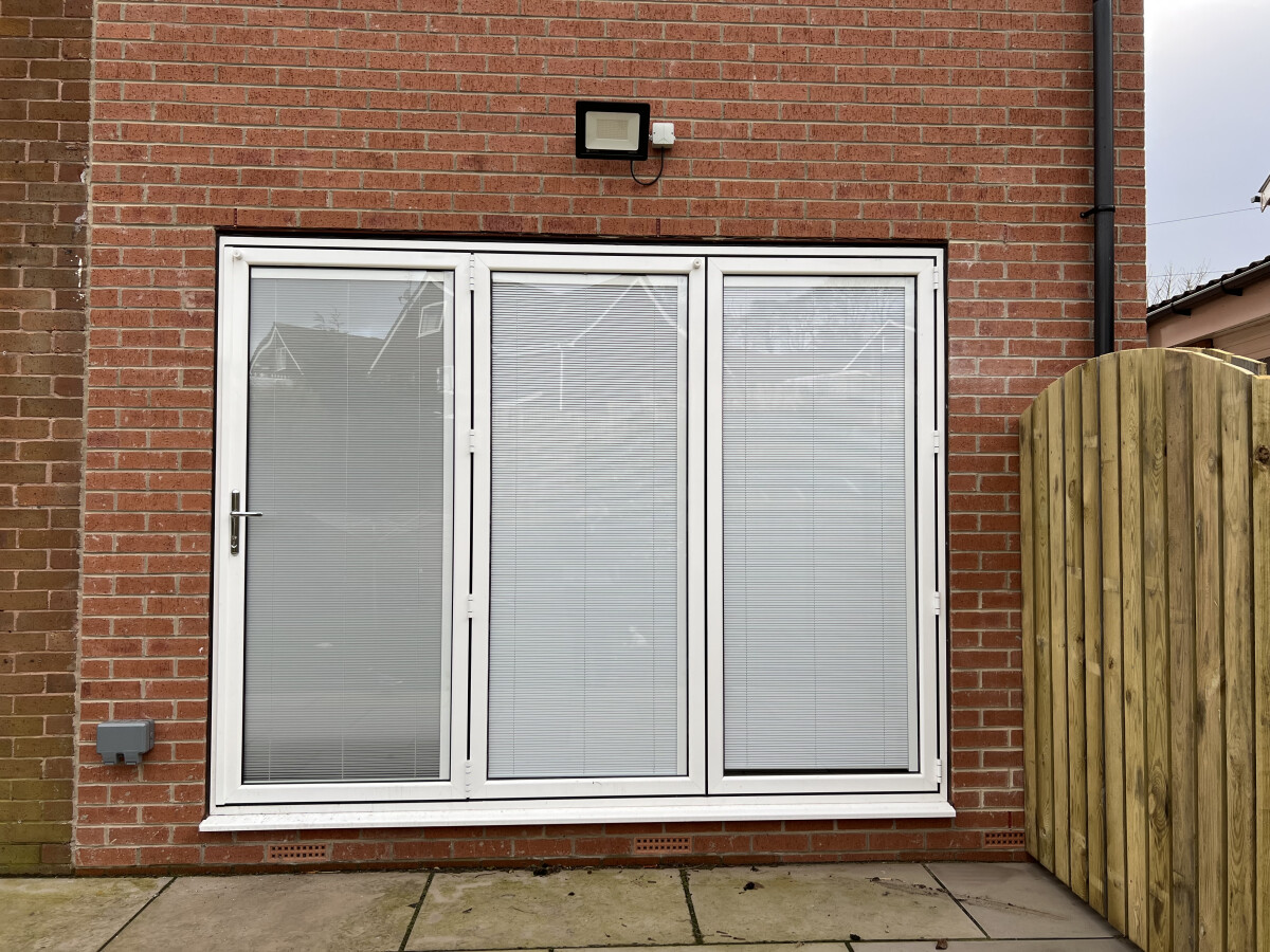 White aluminium bi-fold door with integrated blinds