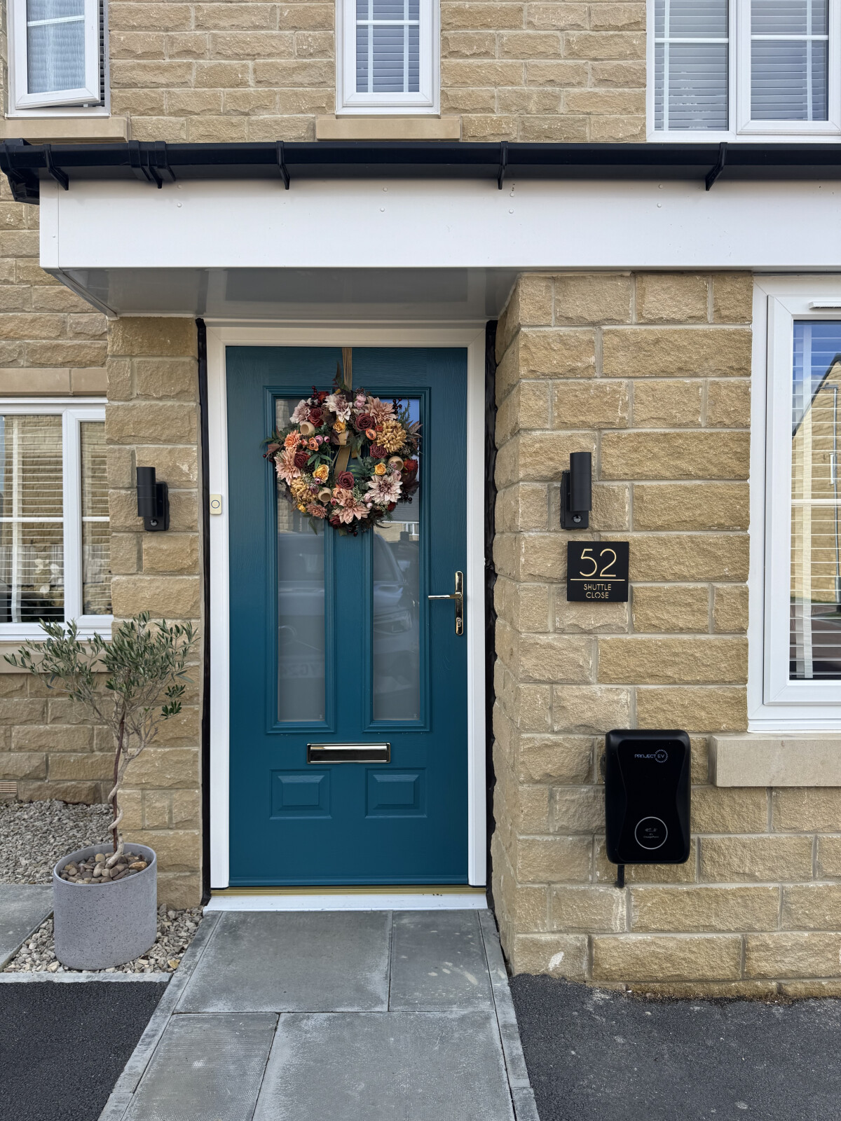 Peacock Blue Edinburgh composite door in white frame with gold furniture