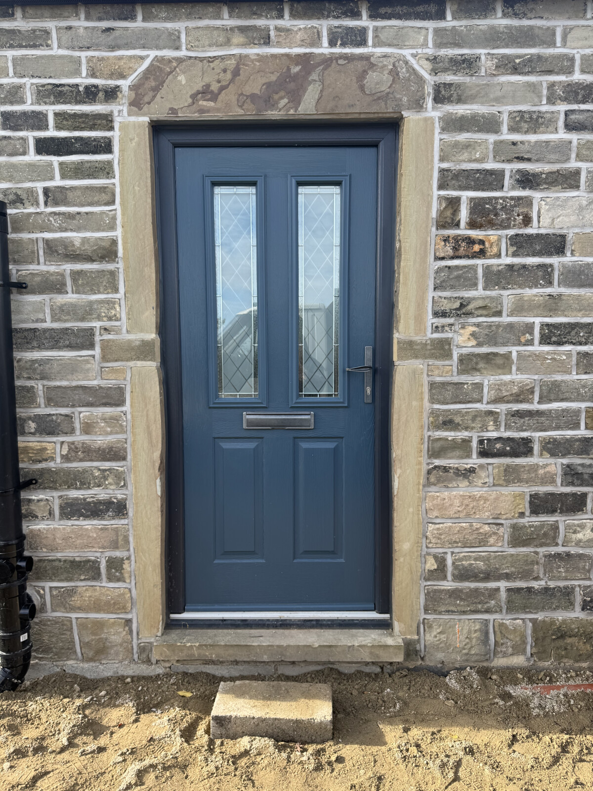 Midnight Grey Ludlow composite door with Anthracite Grey frame, Linear glass and Cottage handle and letterbox