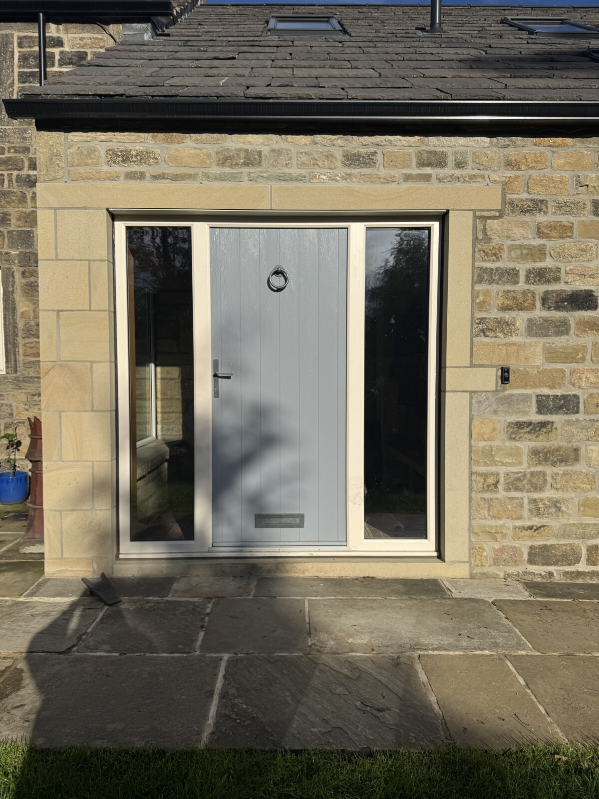 French Grey Flint solid composite door with sidelights in a cream frame, Avon pewter handle, architectural letterbox and ring knocker